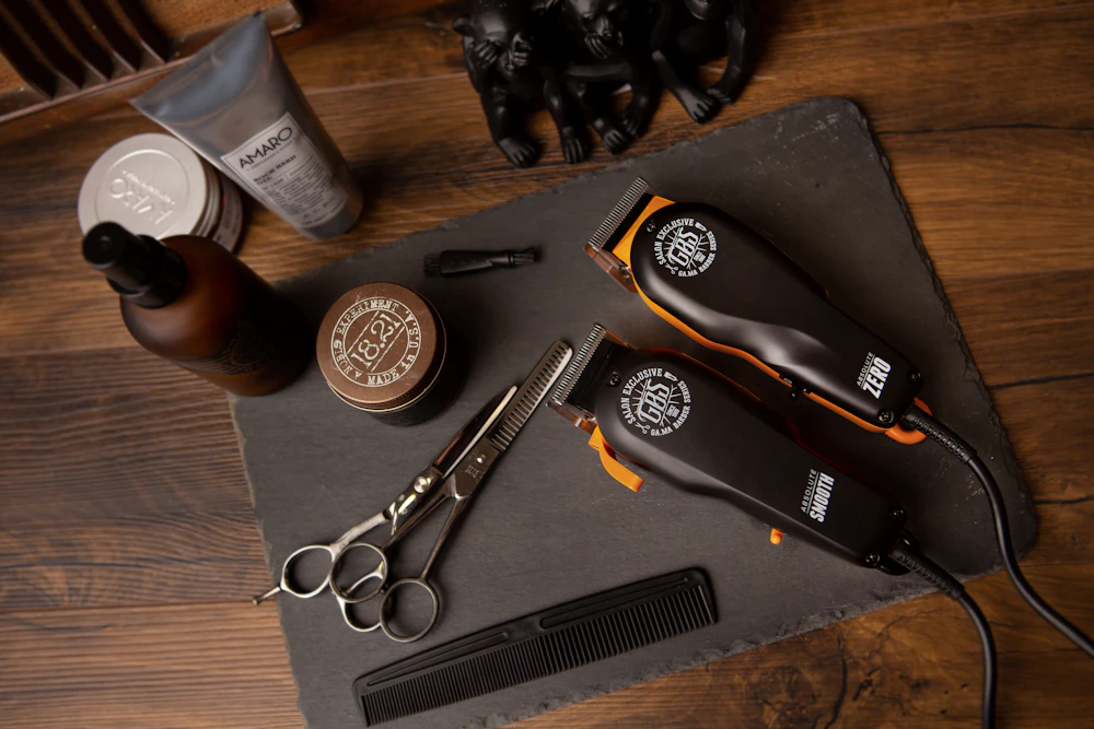 Barber scissors, combs and clippers laid out on a workbench; illustrative stock photograph